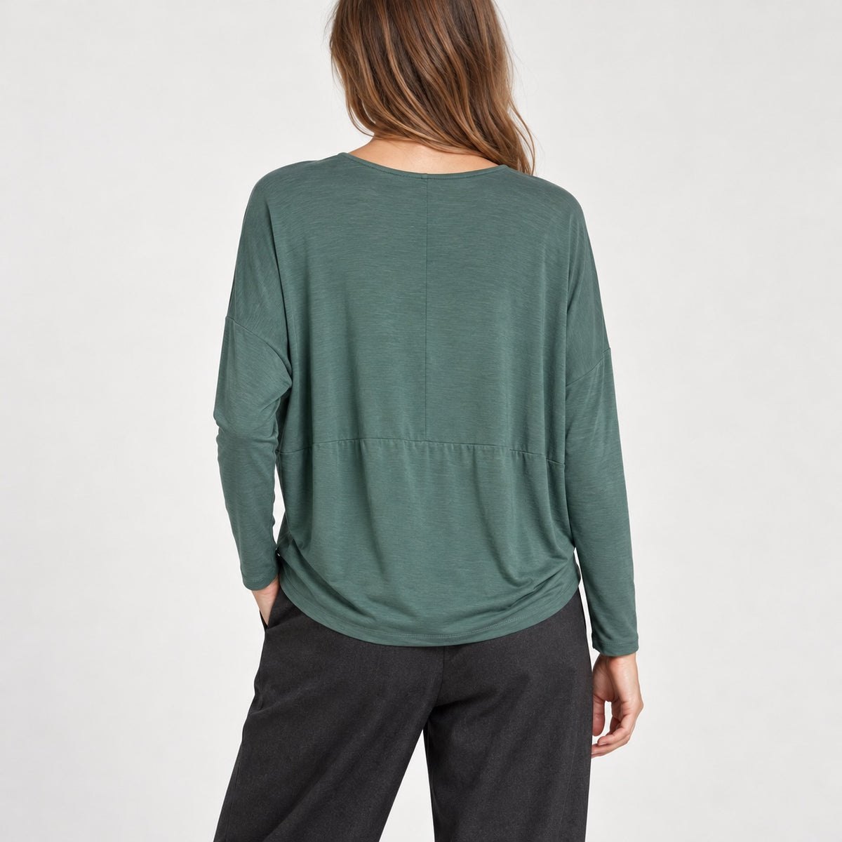 Bluză COS verde salvie oversized pe model, vedere spate